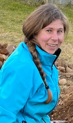 Sarah, one of the hosts, outdoors in a blue jacket